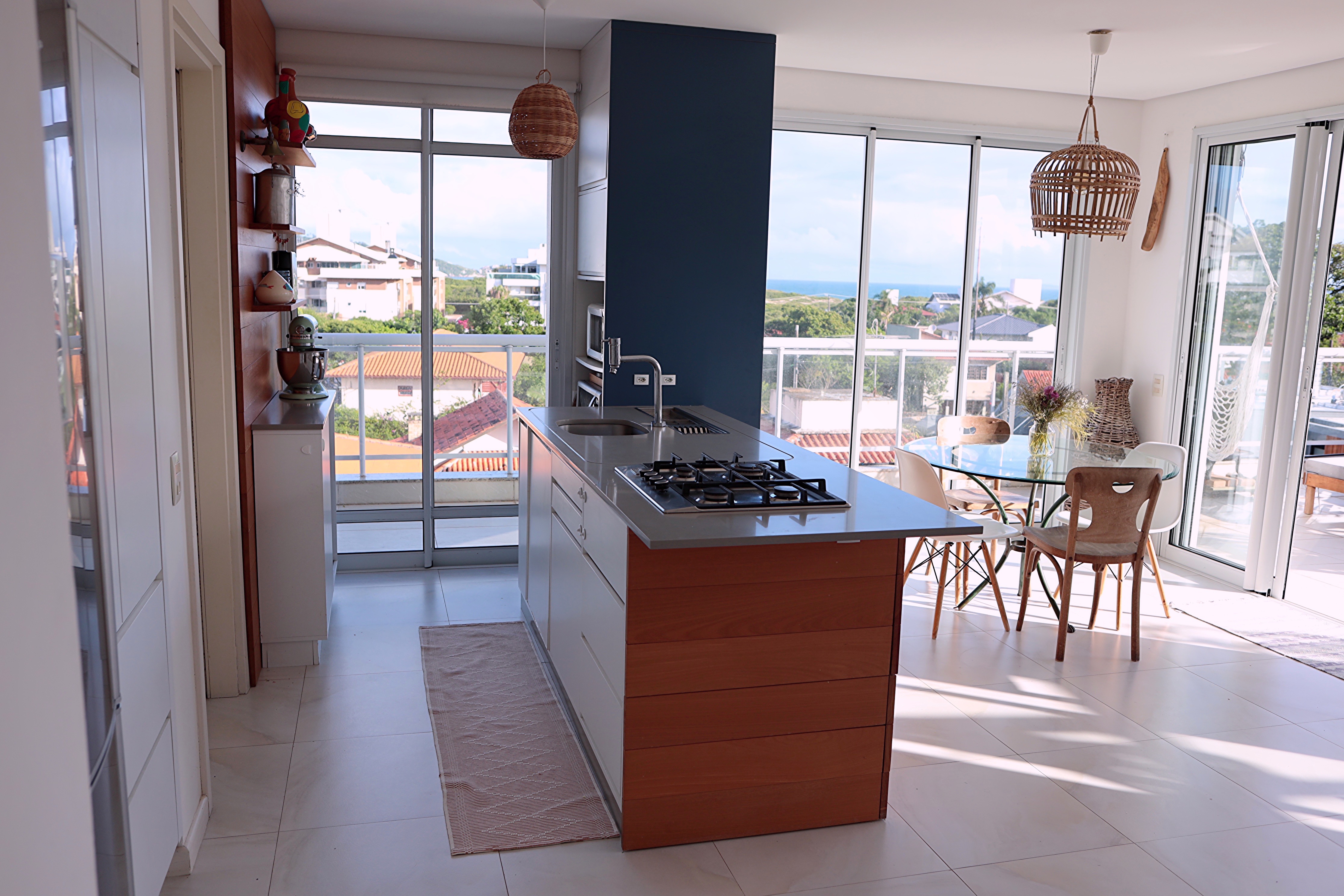 Cozinha gourmet completa com ilha de madeira e vista para a sala na cobertura Campeche