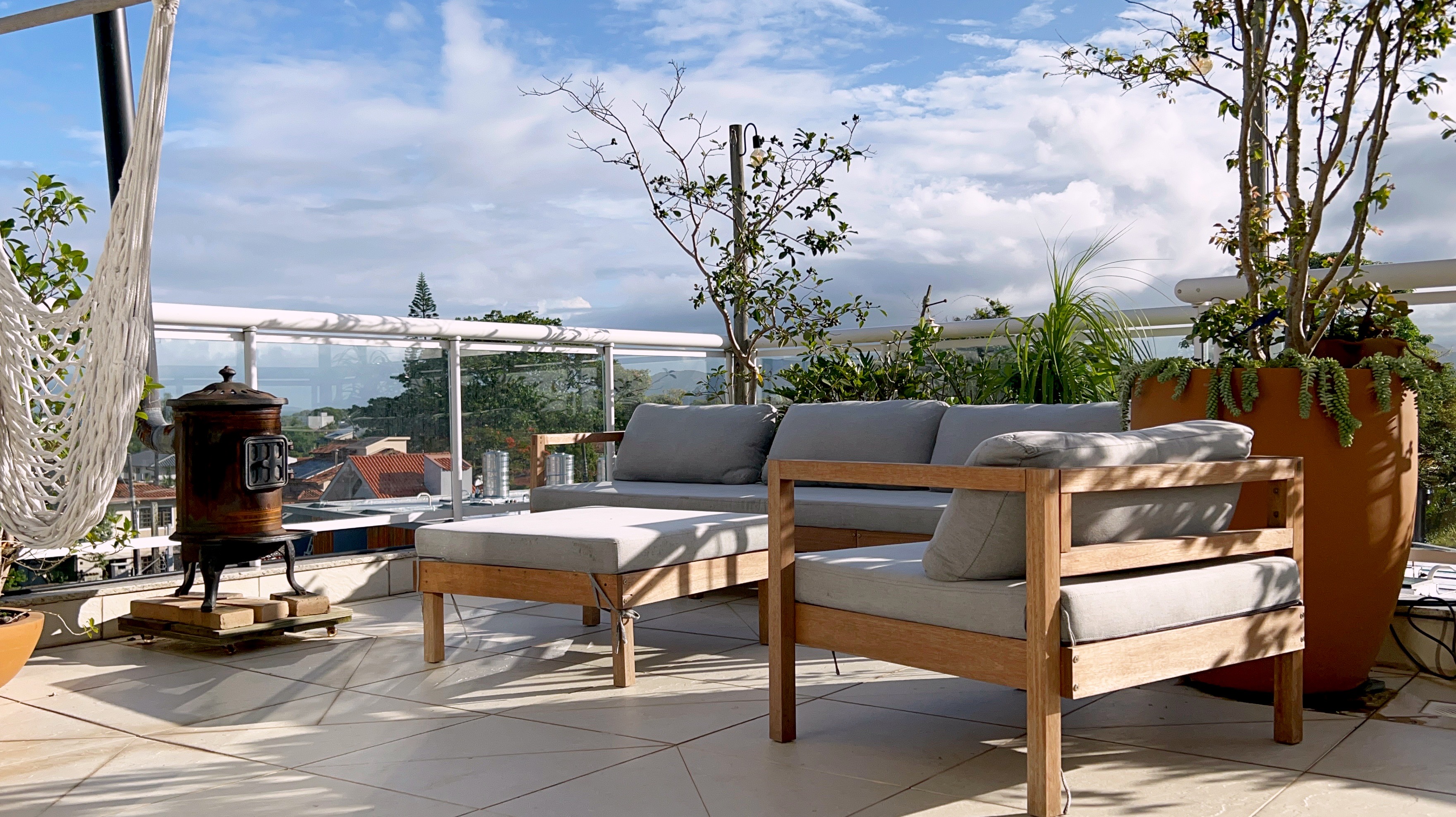Lounge externo com sofá e lareira no terraço da cobertura Campeche Florianópolis
